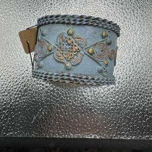 handcrafted cuff bracelet featuring a distinctive green copper patina
finish.